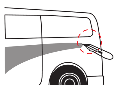 A hand uses a cutting tool to lift a decal corner, highlighted by a red dashed circle.